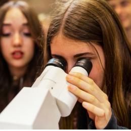 Chica mirando por un microscopio