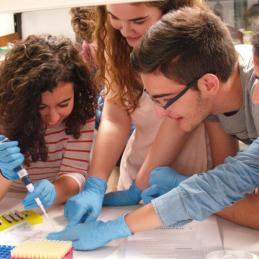 grupo de jóvenes sonrientes trabajando con pipeta